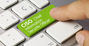 A finger pressing a green keyboard key labeled CISO Chief Information Security Officer.