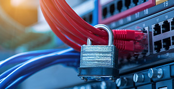 Network cabling comes from a server secured with a padlock.