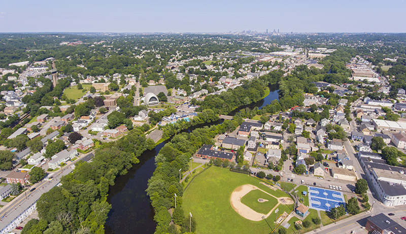 An aerial view of Waltham, MA, with the Charles River and a baseball field.