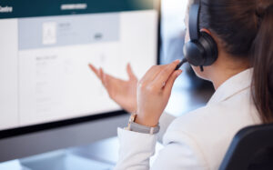A woman on a headset talking to a customer for remote IT support.