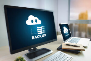 Computer monitors on a disk that show a cloud backup progress.